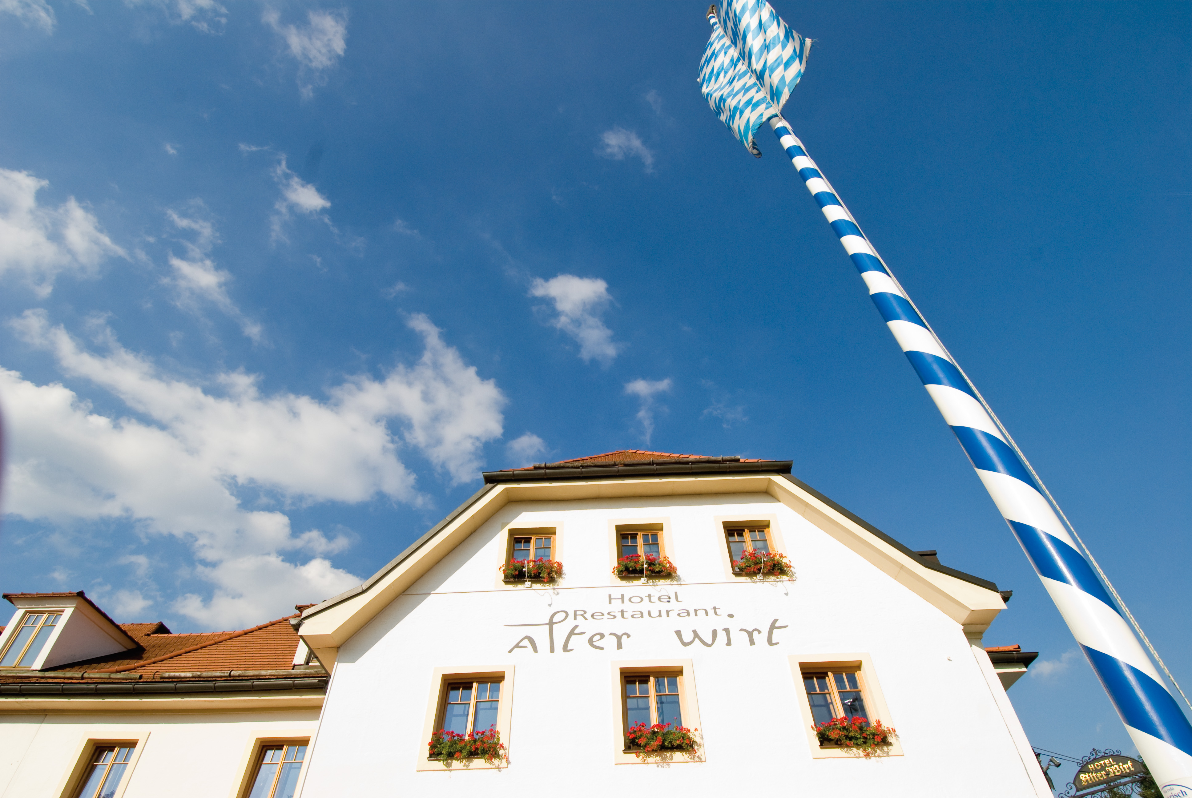 Außenansicht des Alten Wirts mit Maibaum