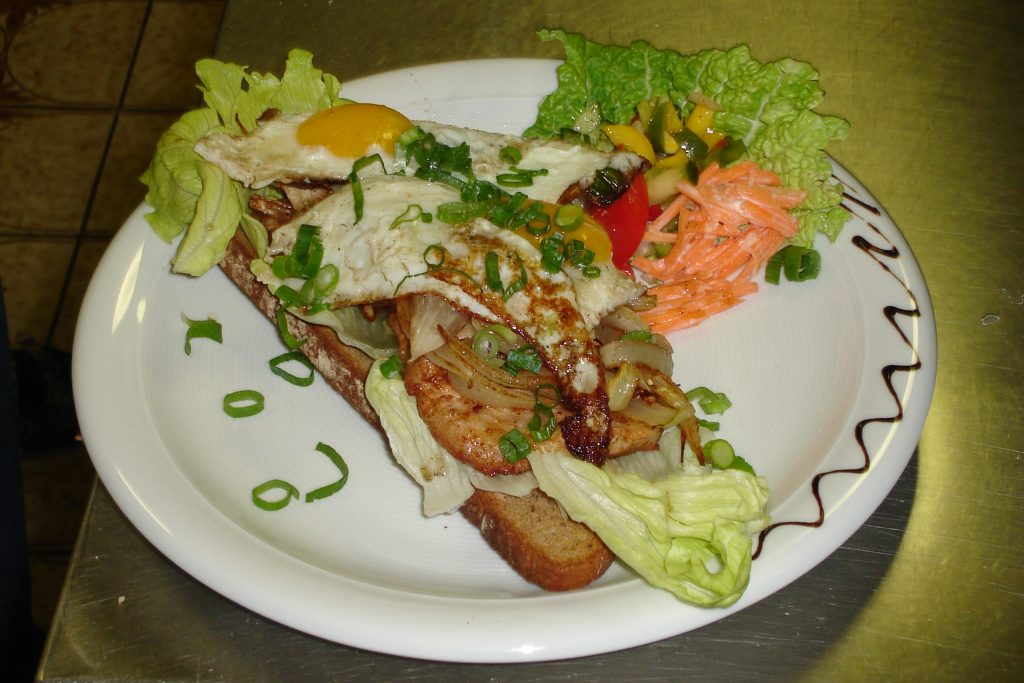 Ein Teller mit Fleisch und Ei auf einer Scheibe Brot