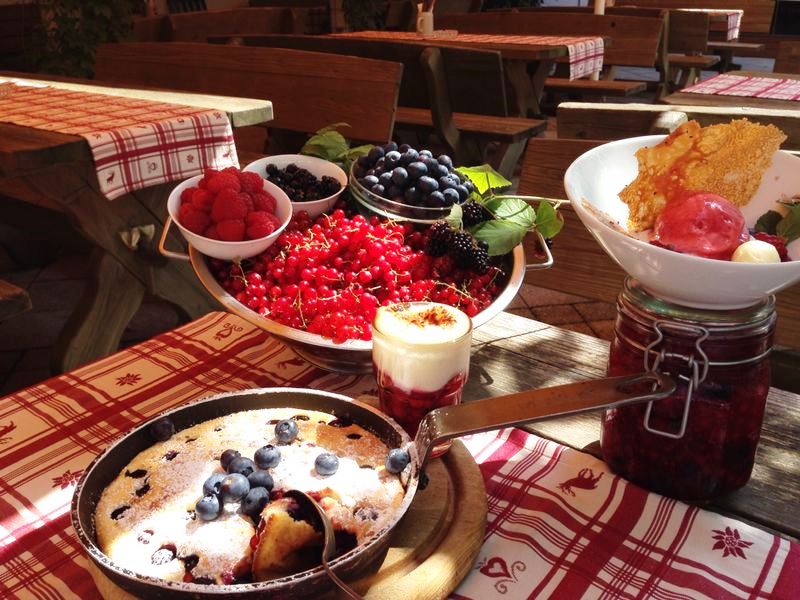 verschiedene Desserts angerichtet auf einem Tisch mit einer großen Auswahl an frischen Beeren