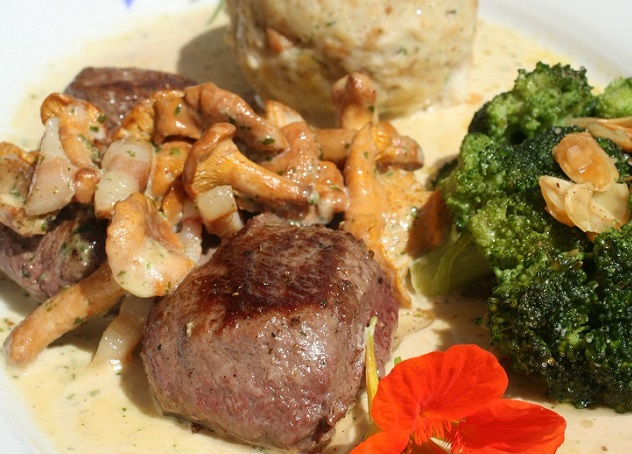 Teller mit Fleischstücken und Beilagen