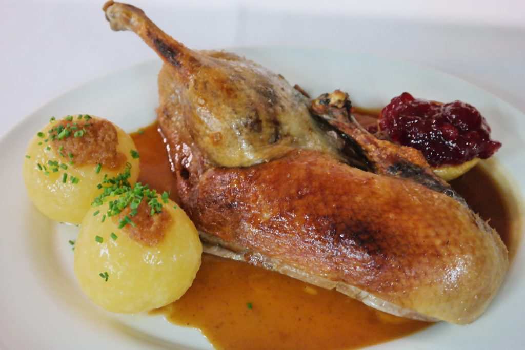 halbe Gans mit Kartoffelknödel und Soße auf Teller