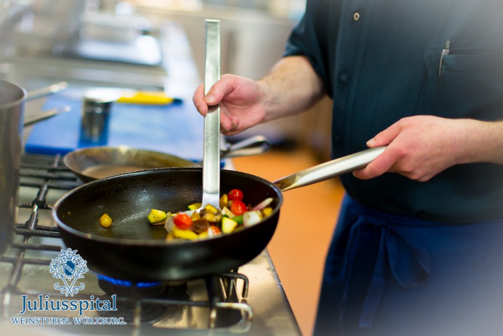 Ein Koch beim Braten von Gemüse