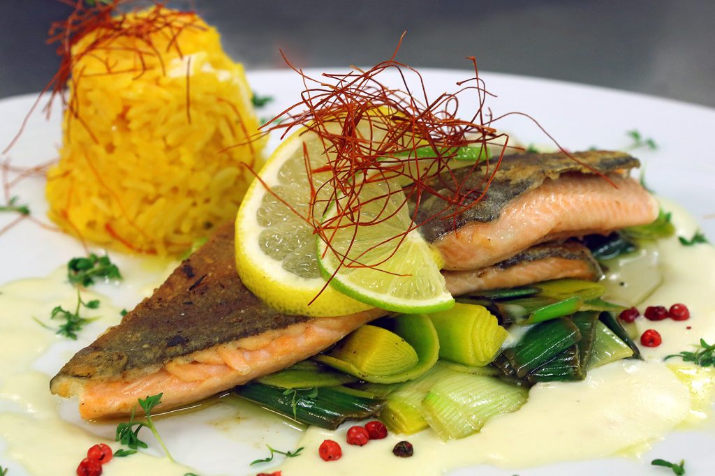 Ein Teller mit Lachsforellenfilet, Reis und Gemüse