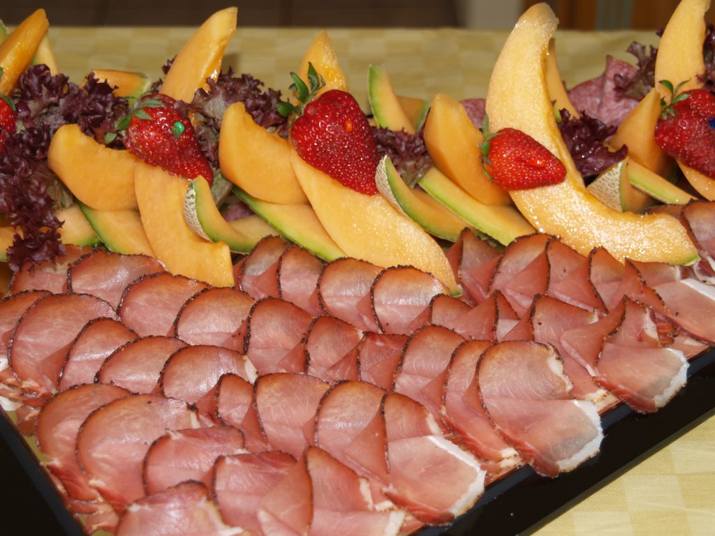 Eine Platte mit Wurstaufschnitt und Obst