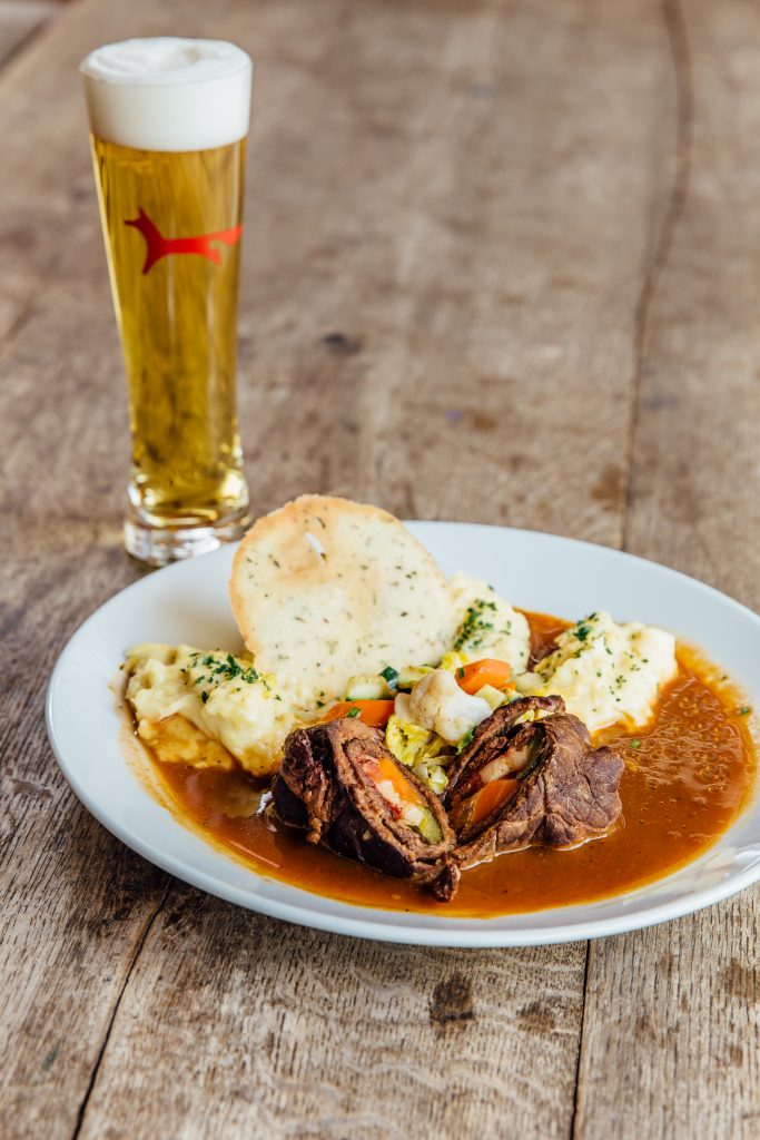 Teller mit Essen und ein Glas Bier