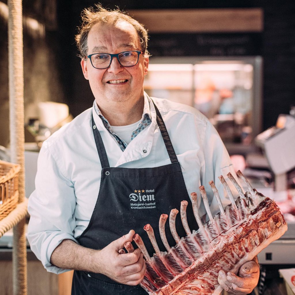 Karl DIEM mit Fleischstück in der Hand