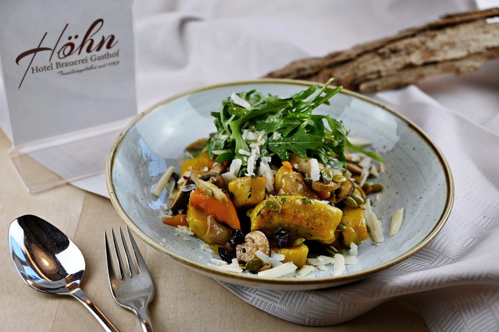 Hausgemachte Gnocchis mit Pilzen, Cranberries, Frühlingszwiebeln und marinierter Rucola