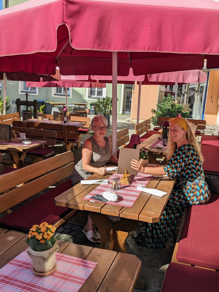 Wirtshaus am Spitalplatz Terrasse mit 2 Personen am Tisch sitzend