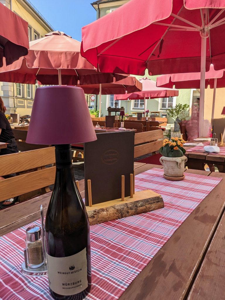 Wirtshaus am Spitalplatz Terrasse mit Schirmen und eingedeckten Tischen