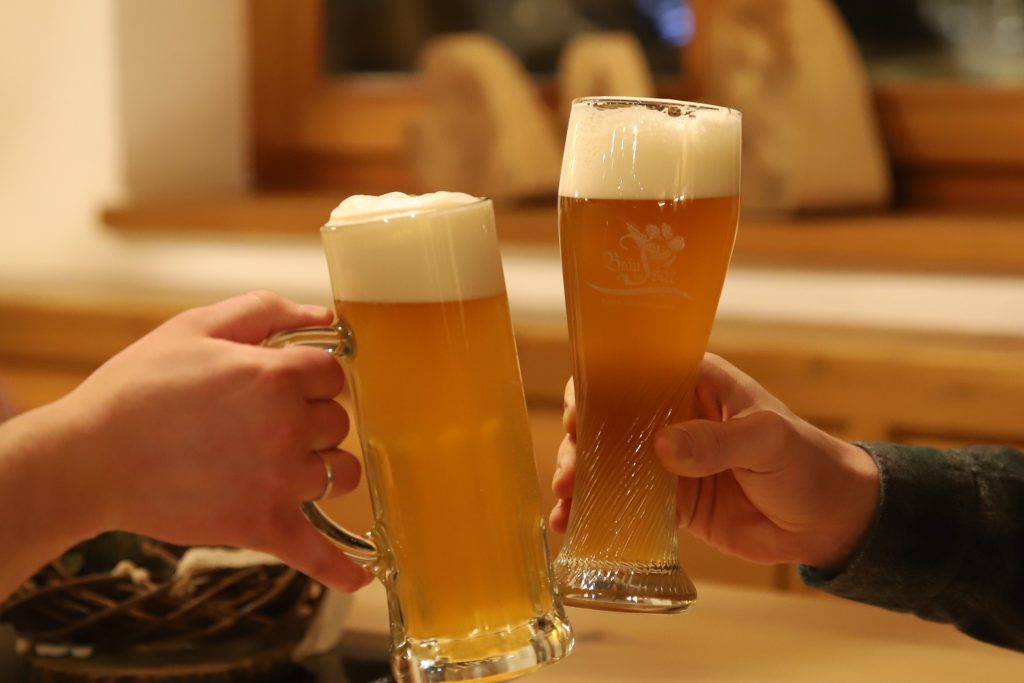Zwei Biergläser gefüllt anstoßen