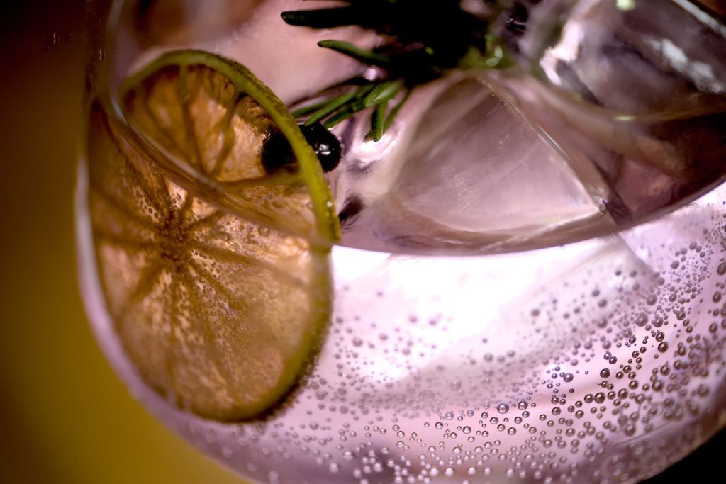 Gin in bauchigem Gals mit Zitronenscheibe in Nahaufnahme